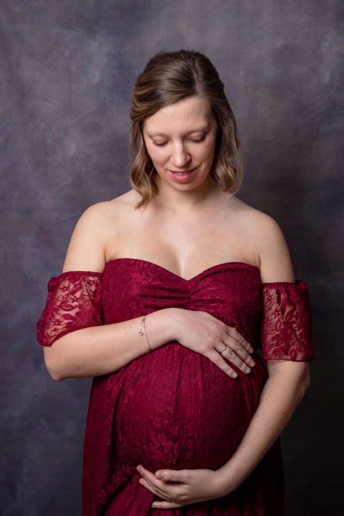 Femme enceinte au studio avec robe bordeaux