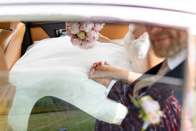 Futurs mariés qui se tiennent la main dans leur voiture