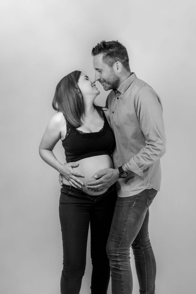 Couple lors d'un shooting grossesse au studio en noir et blanc